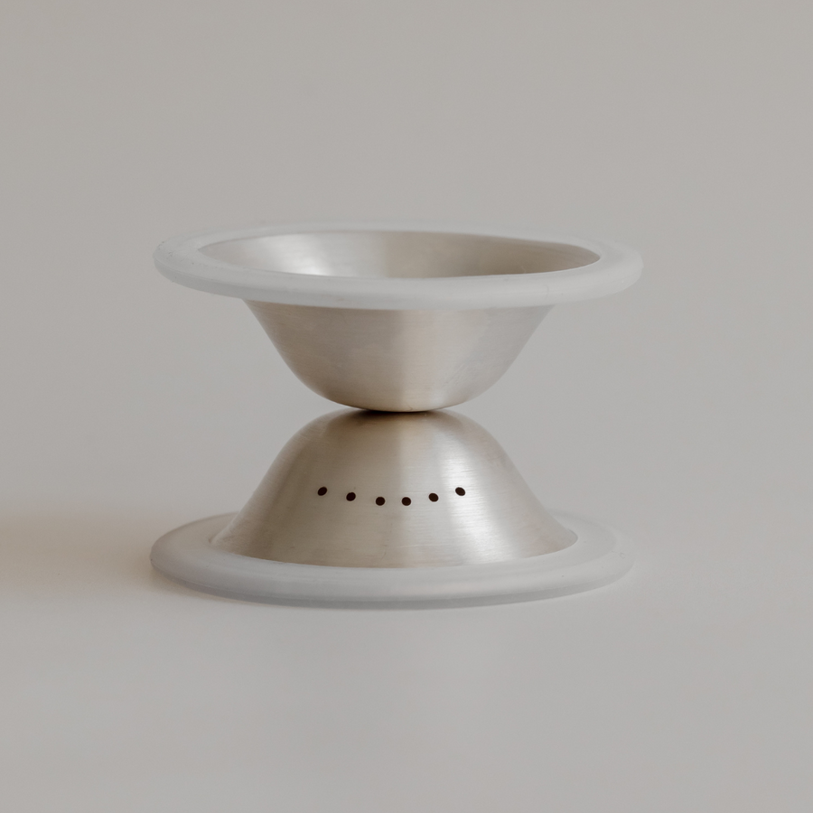 Stainless steel Bosom Ritual™ Objects hourglass with non-slip base on a plain background by Mammae The Embodied Mother.