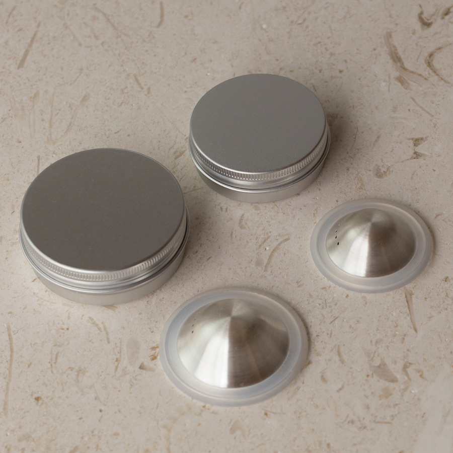A set of Bosom Ritual™ Objects with lids on a marble surface, designed to heal and protect, brought to you by Mammae The Embodied Mother.