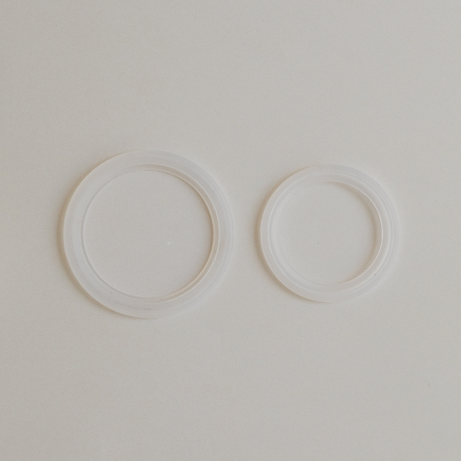 Two white circular Bosom Ritual™ Objects by Mammae The Embodied Mother on a plain background.