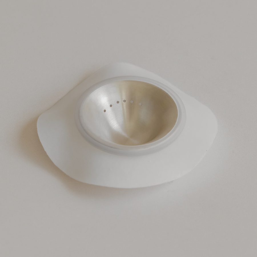 A Bosom Ritual™ Objects dental implant healing cap, made of 999 Fine Silver, on a white surface.