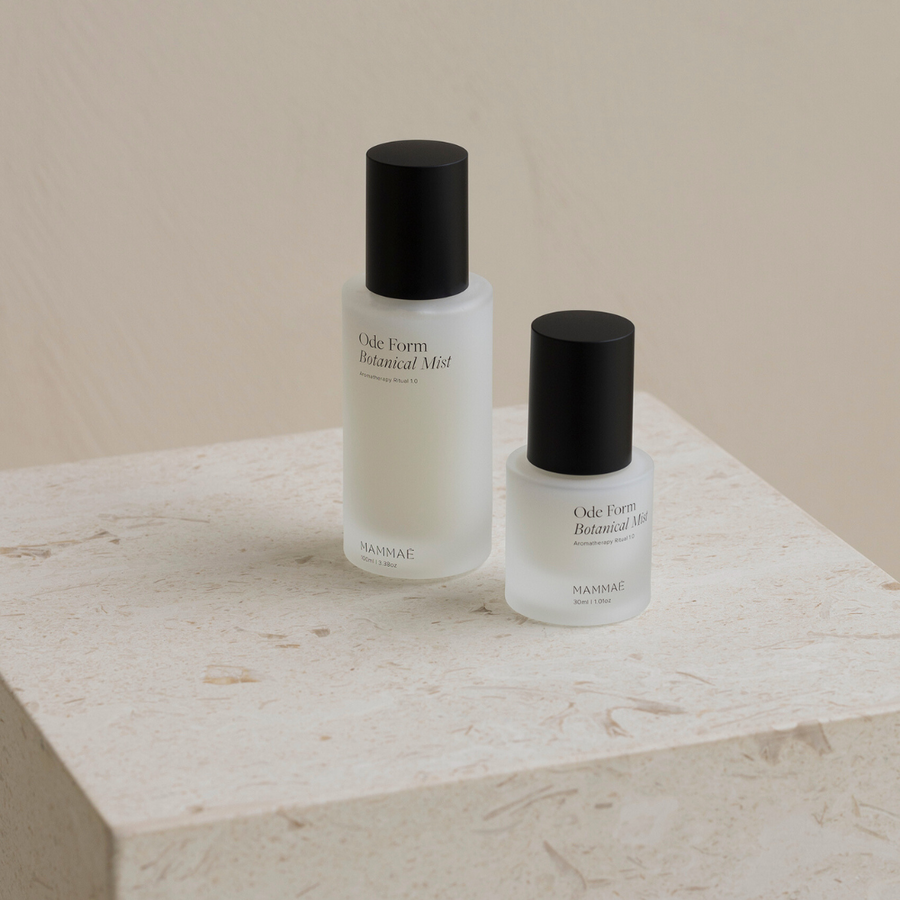 Two bottles of Mammae The Embodied Mother's Ode Form™ Botanical Mist sitting on top of a marble slab.