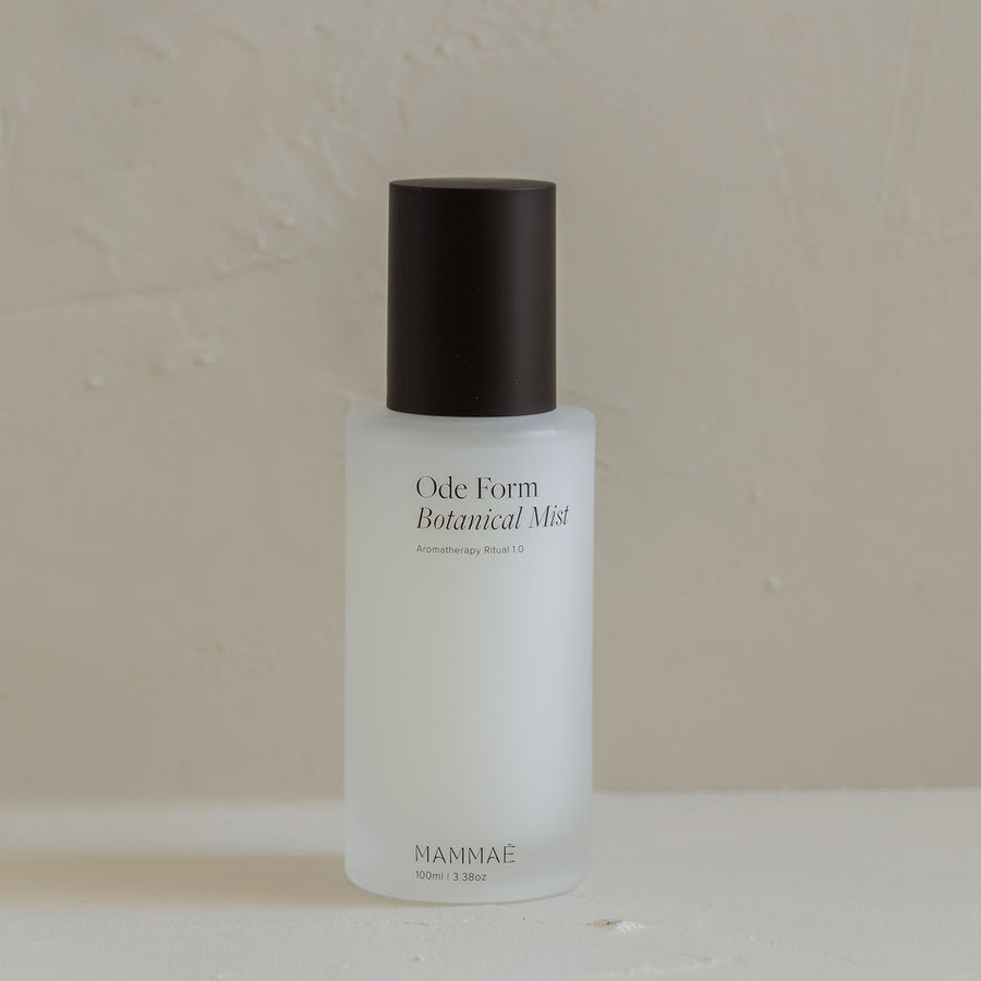 A bottle of Ode Form™ Botanical Mist by Mammae The Embodied Mother on a white surface, promoting aromatherapy benefits.