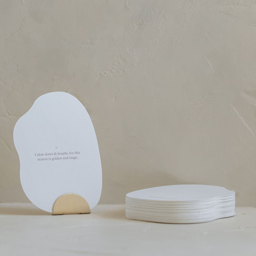A white Bosom Reflections card with an affirmation quote on it sitting on a table, branded by Mammae The Embodied Mother.