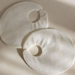 Two natural eco-friendly bamboo reusable fabric covers on a beige background with soft shadows of the Mammae hot and cold packs for breastfeeding and lactation support. 