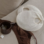 Mammae Breast Pack for lactation support resting on a beige surface with a cup of nursing tea and chocolate brown bra. 
