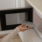 postpartum woman using a microwave with a transparent mammae hot and cold breast care compress to heat for lactation support. 