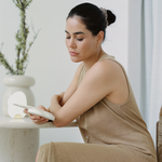 Breastfeeding mother sitting at a table reading her breastfeeding affirmation ritual to support her breastfeeding experience designed to enhance lactation, improve breastfeeding outcomes. Baby shower gift idea or baby shower gift registry.