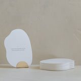 A white Bosom Reflections card with an affirmation quote on it sitting on a table, branded by Mammae The Embodied Mother.