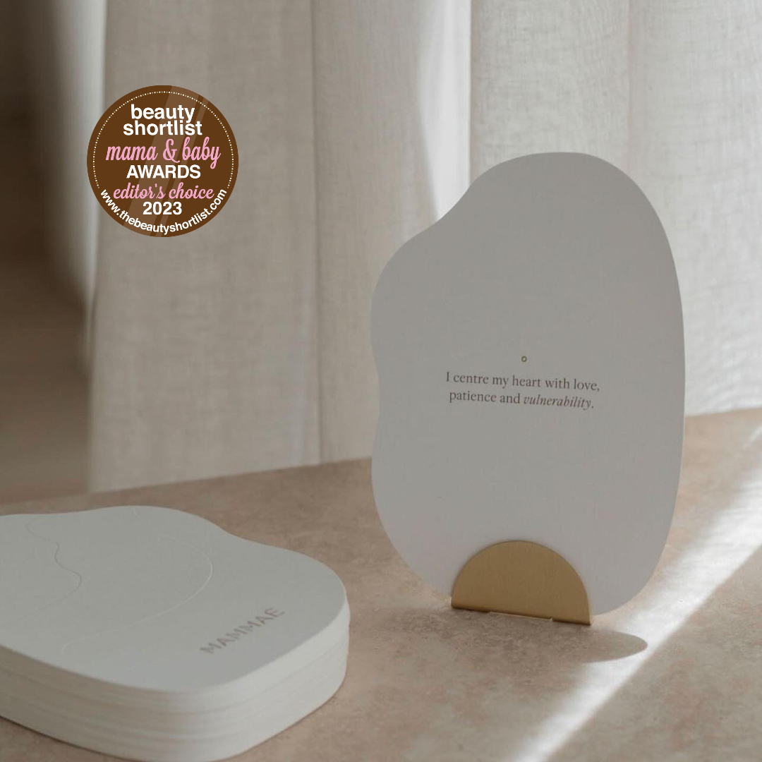 A set of Bosom Reflections postpartum cards on a table next to a curtain from Mammae The Embodied Mother, providing support and guidance for nursing mothers during the mastitis recovery.