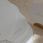 A stack of white breastfeeding affirmation cards called the Bosom Reflections providing positive mindfulness on lactation and breastfeeding support, placed on a table in a nursery. 