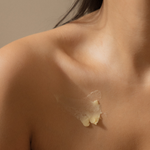 A new mother who is breastfeeding her baby with the Bosom Ritual™ Balm from Mammae The Embodied Mother on her breast to support nipple damage. 