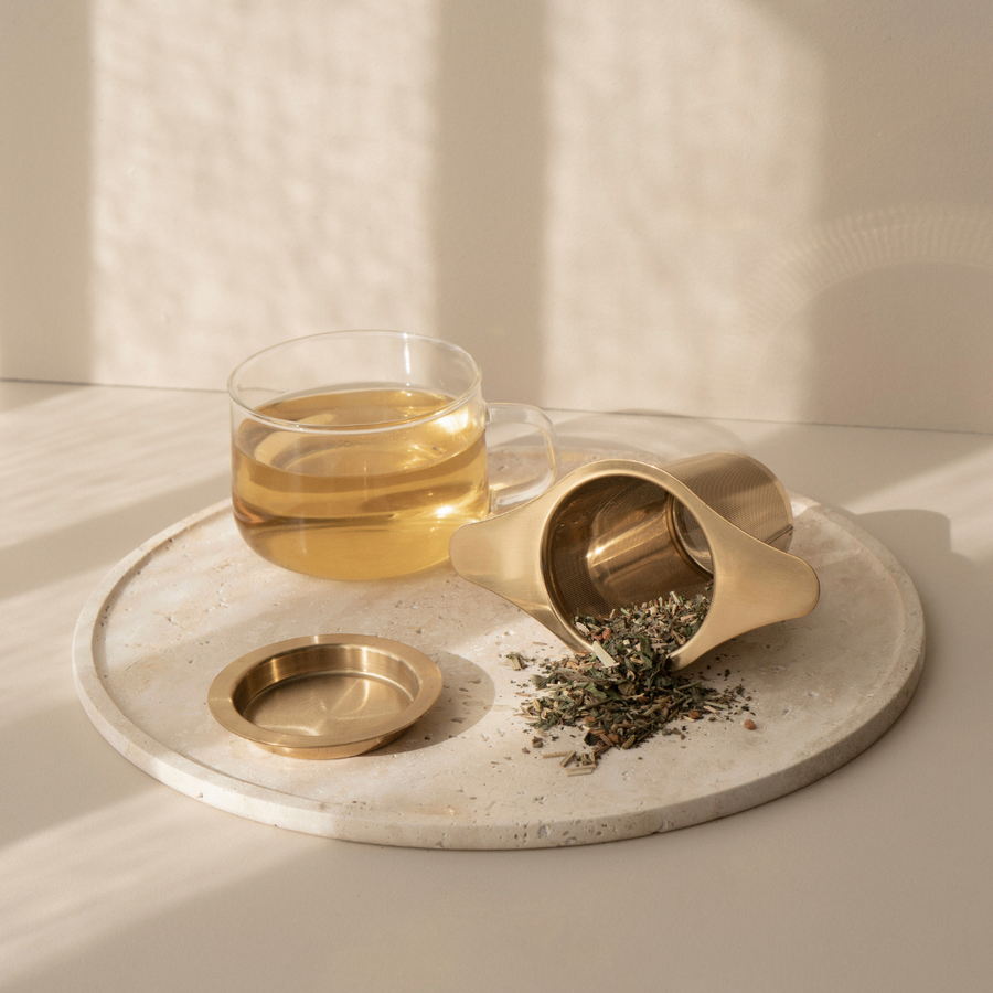 A cup of Bosom Ritual™ Infusion tea for breastfeeding mothers on a marble tray from Mammae The Embodied Mother.