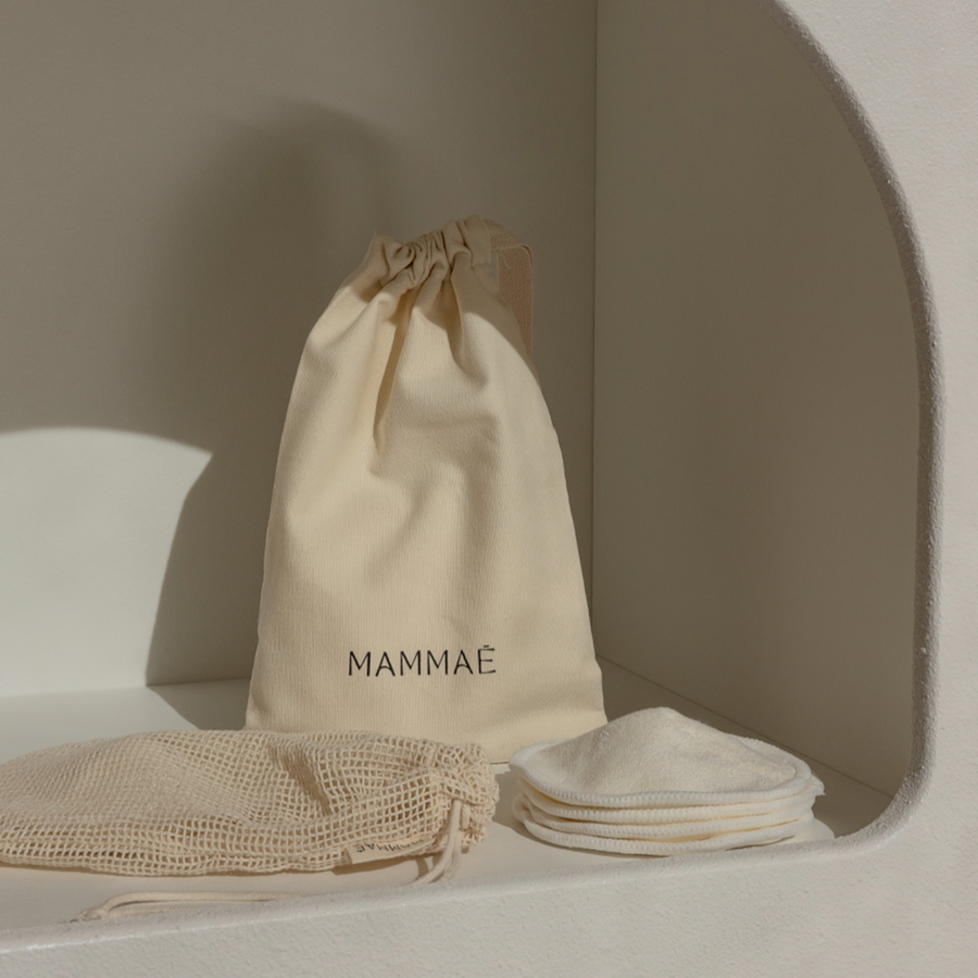 an organic cotton canvas drawstring keepsake bag paired with an organic washable mesh bag and a set of the Mammae Bosom Wearables Breast Pads for nursing mothers to support lactation and  milk supply.