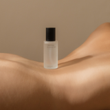 A woman breastfeeding while using the Ode Form™ Botanical Mist bottle from Mammae The Embodied Mother.
